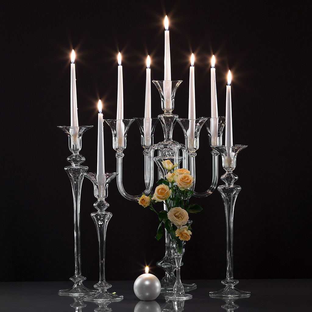 White candles on glass candelabra and candleholders on a black background. The Carmen collection designed by Gabriela Seres and handmade in Bucharest, Romania atelier.